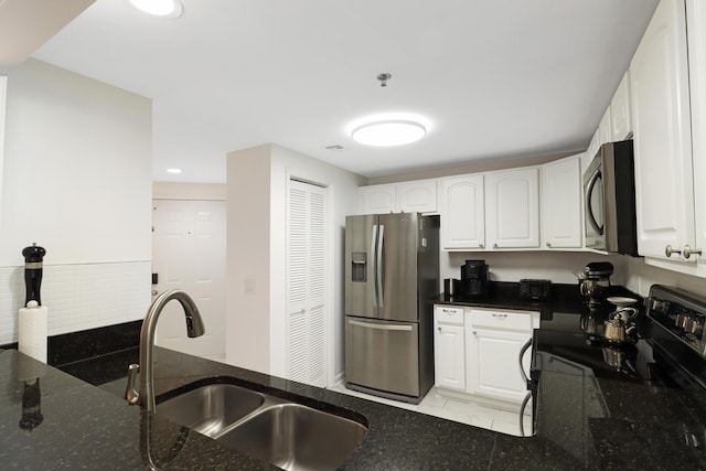 kitchen with a sink, stainless steel appliances, and white cabinetry