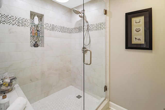 full bath with a shower stall and baseboards