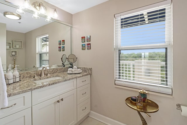 bathroom featuring baseboards, plenty of natural light, and vanity