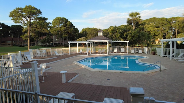 pool with a gazebo, a patio, a pergola, and fence