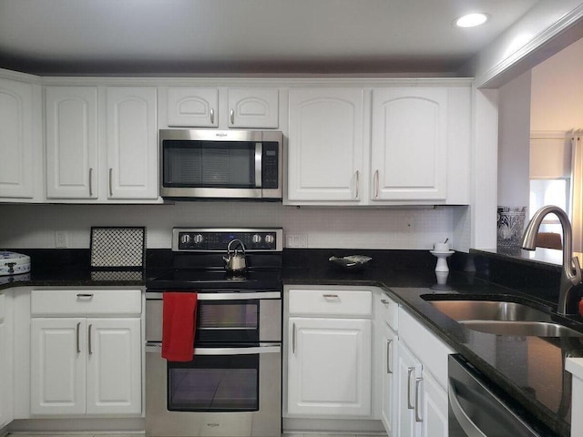 25 Players Clb Unit 25, Miramar Beach, FL 32550 - kitchen featuring dark stone countertops, tasteful backsplash, stainless steel appliances, a sink, and white cabinetry