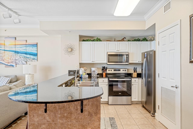 kitchen featuring stainless steel appliances, a sink, a peninsula, and light tile patterned floors