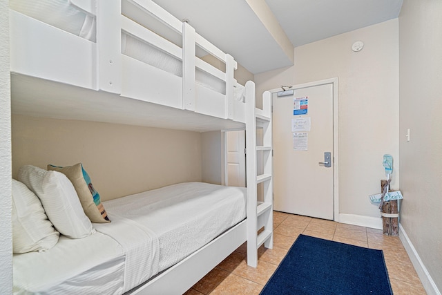 bedroom with tile patterned flooring and baseboards