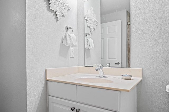 bathroom with a textured wall and vanity