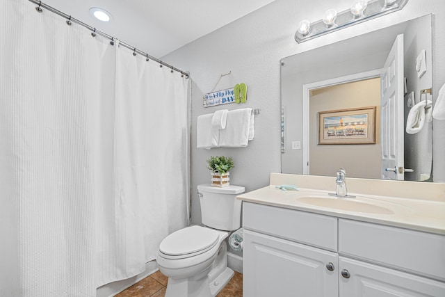 bathroom with tile patterned flooring, vanity, and toilet