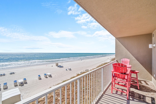 balcony with a water view and a beach view