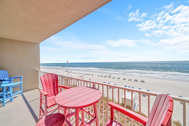 balcony with a water view and a beach view