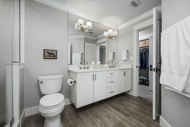 full bathroom with wood finished floors, visible vents, double vanity, crown molding, and toilet