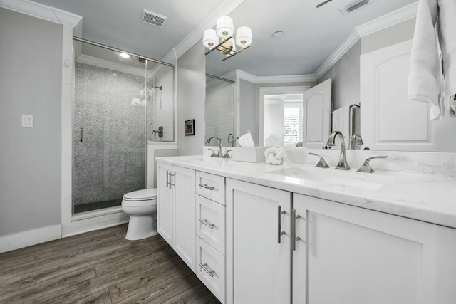 bathroom featuring crown molding, wood finished floors, visible vents, and a sink