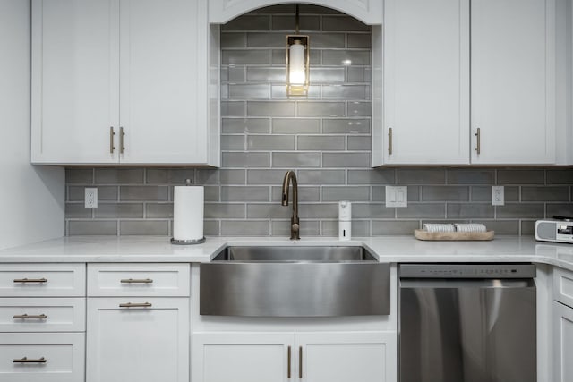 kitchen with tasteful backsplash, dishwasher, white cabinetry, and a sink