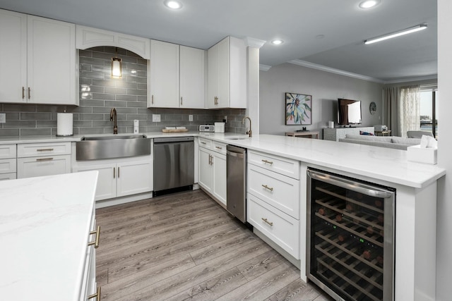 kitchen featuring wine cooler, dishwasher, light wood-style flooring, a peninsula, and a sink