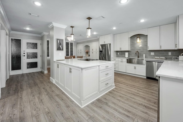 kitchen with arched walkways, a sink, ornamental molding, stainless steel appliances, and tasteful backsplash