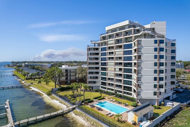 view of building exterior featuring a water view and fence