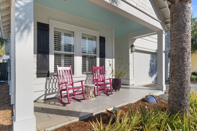 view of patio / terrace featuring a porch and a garage