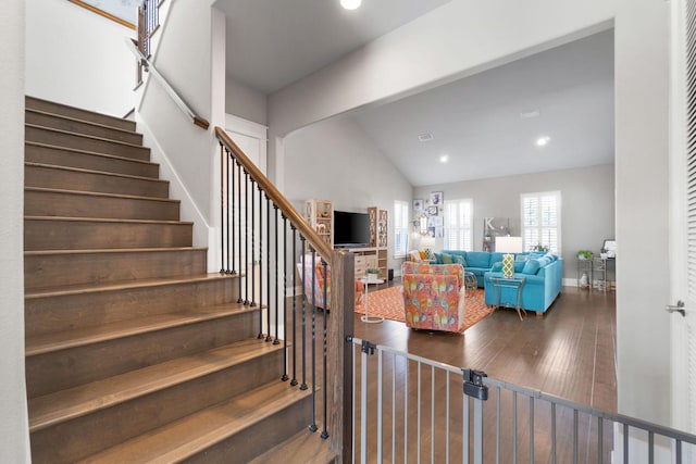 staircase with baseboards, vaulted ceiling, hardwood / wood-style floors, and recessed lighting