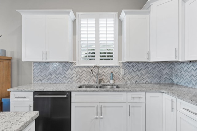 kitchen featuring dishwashing machine, tasteful backsplash, a sink, and white cabinets