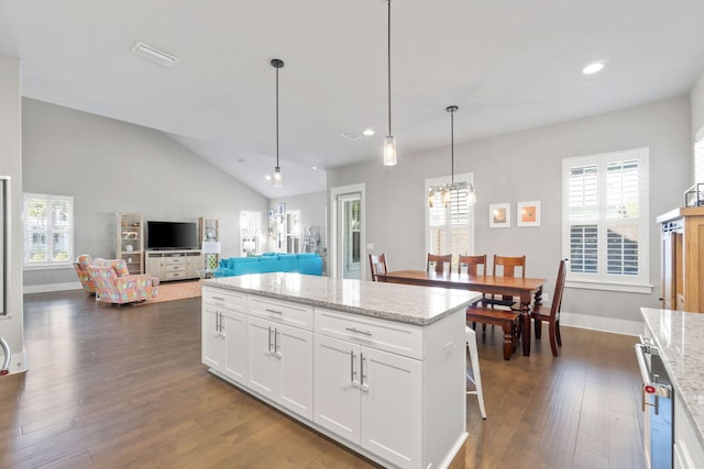 kitchen featuring vaulted ceiling, dark wood-type flooring, white cabinets, and a healthy amount of sunlight