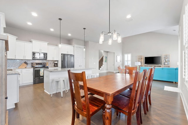 dining room featuring dark wood-type flooring, recessed lighting, and stairs