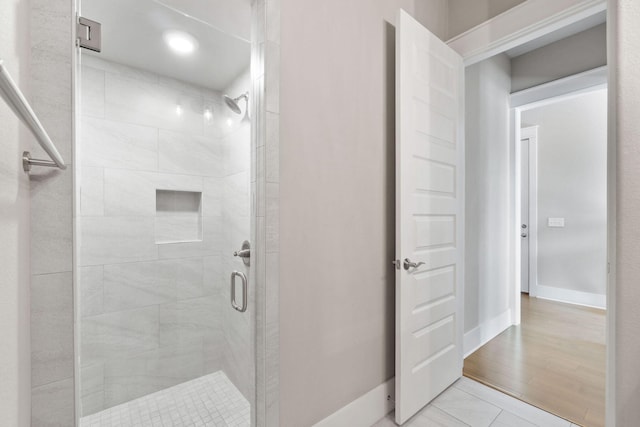 full bath with a shower stall and baseboards