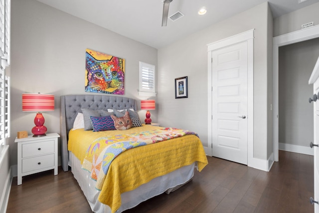 bedroom with visible vents, baseboards, and wood finished floors