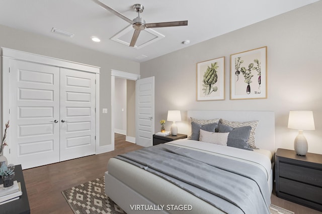 bedroom with a closet, visible vents, a ceiling fan, attic access, and wood finished floors