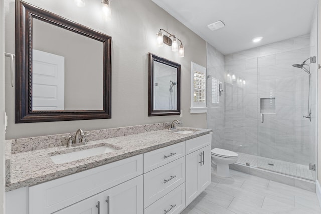 bathroom with toilet, a stall shower, and a sink