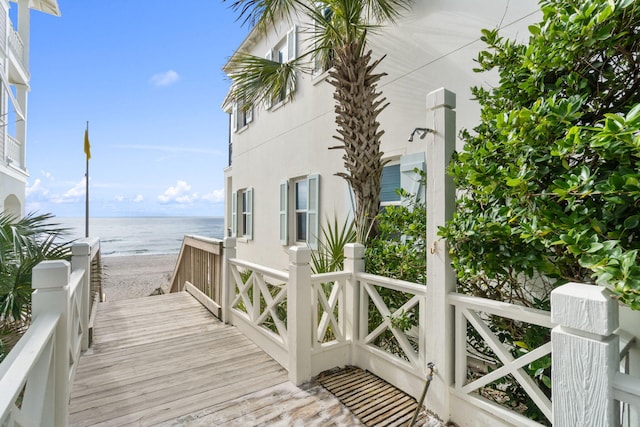 exterior space featuring a water view, a view of the beach, and stucco siding