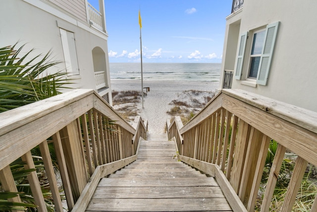 view of property's community featuring a water view and a beach view