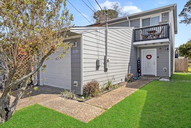 view of front of home featuring an attached garage, a front yard, and a balcony