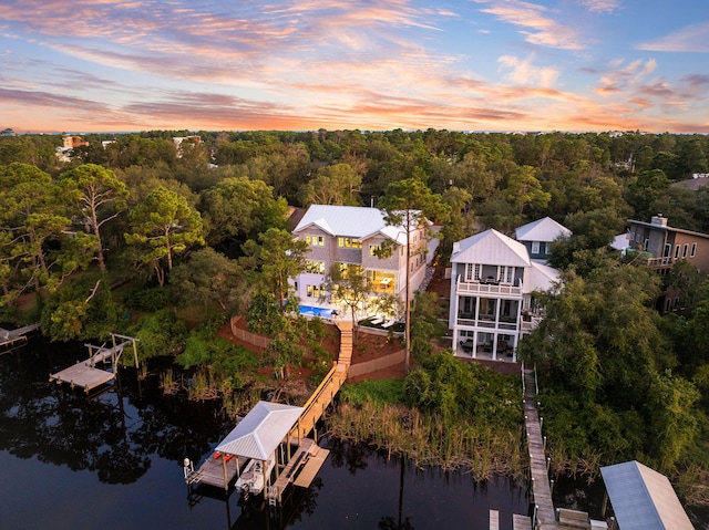 aerial view featuring a forest view and a water view