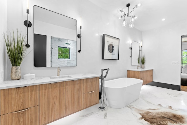 full bath featuring a soaking tub, marble finish floor, vanity, and a healthy amount of sunlight