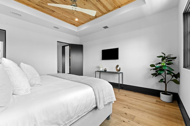 bedroom featuring a raised ceiling, wood ceiling, visible vents, and light wood finished floors