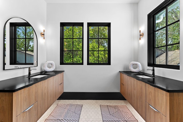 bathroom featuring a sink, plenty of natural light, and two vanities