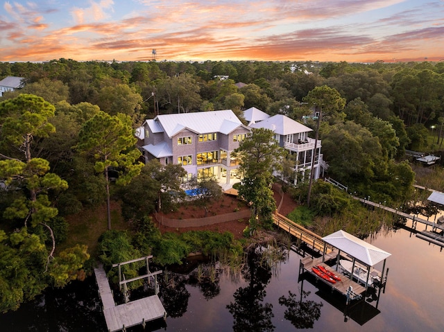 aerial view at dusk with a forest view and a water view