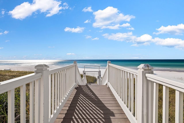 surrounding community featuring a water view and a beach view