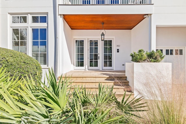 doorway to property featuring covered porch, a balcony, and stucco siding