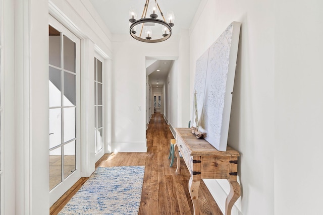 entryway with a notable chandelier and wood finished floors