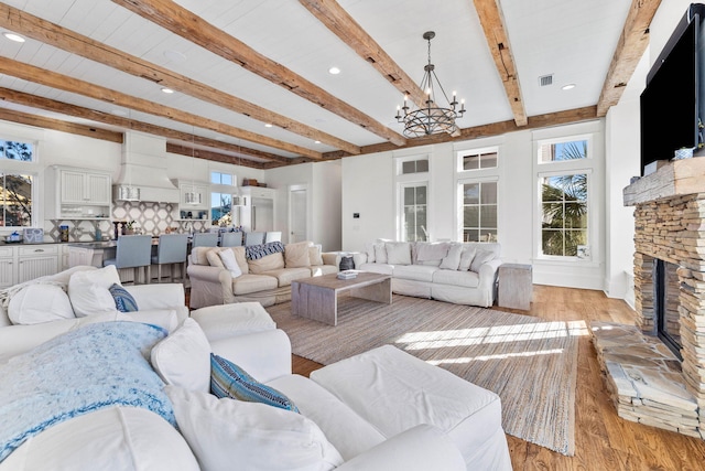 living room featuring light wood-type flooring, a healthy amount of sunlight, visible vents, and a fireplace