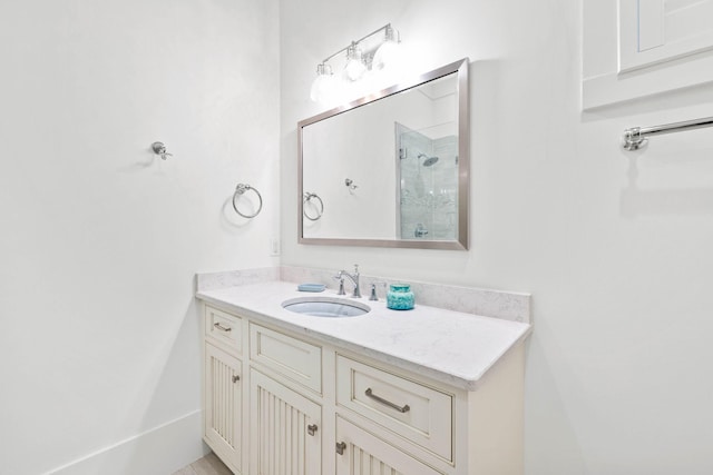 bathroom featuring tiled shower and vanity