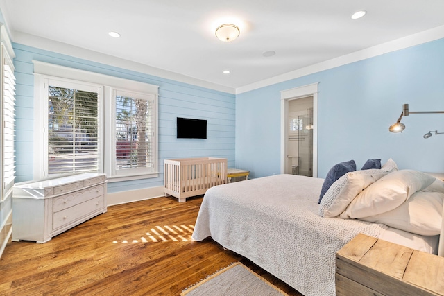 bedroom featuring wood walls, wood finished floors, and recessed lighting