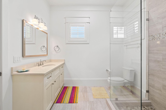 bathroom featuring toilet, walk in shower, and vanity