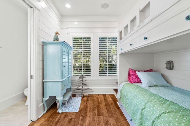 bedroom featuring wooden walls and wood finished floors