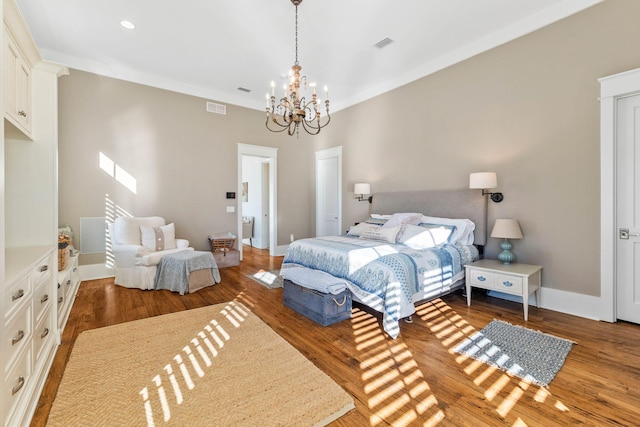 bedroom with wood finished floors, visible vents, and baseboards