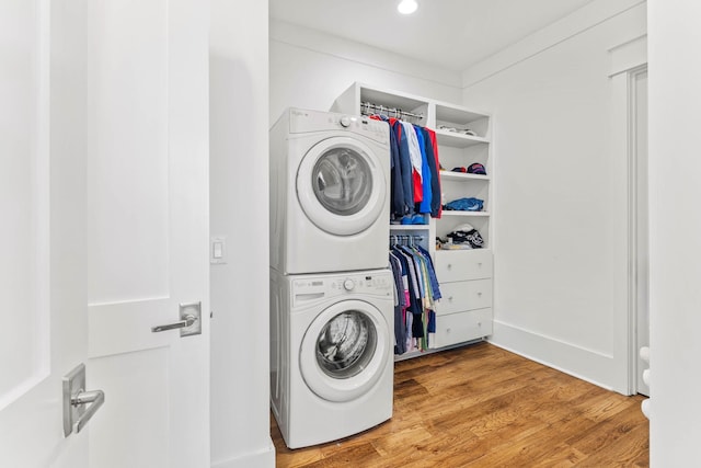 washroom featuring laundry area, light wood-style flooring, and stacked washer / dryer