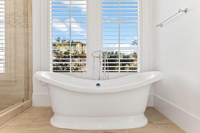 full bathroom with a freestanding tub, a stall shower, and tile patterned flooring