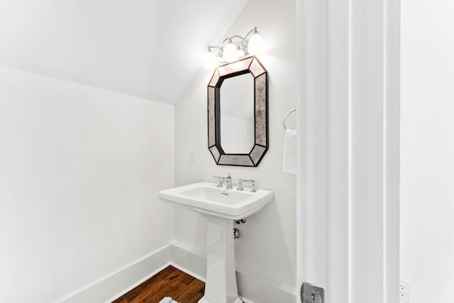 bathroom featuring lofted ceiling, wood finished floors, and baseboards