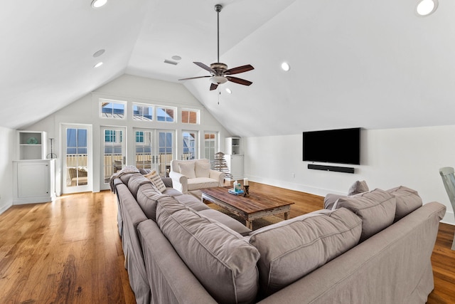 living room featuring vaulted ceiling, french doors, and light wood finished floors