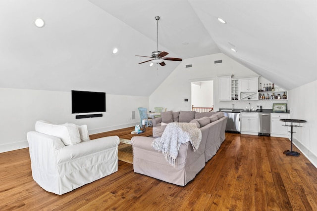 living room featuring dark wood-style floors, lofted ceiling, indoor wet bar, and visible vents