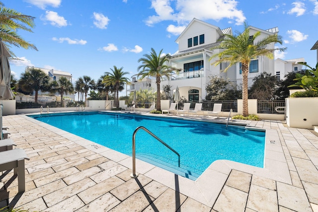 community pool featuring fence and a patio