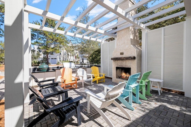 view of patio / terrace with area for grilling, a fireplace, and a pergola